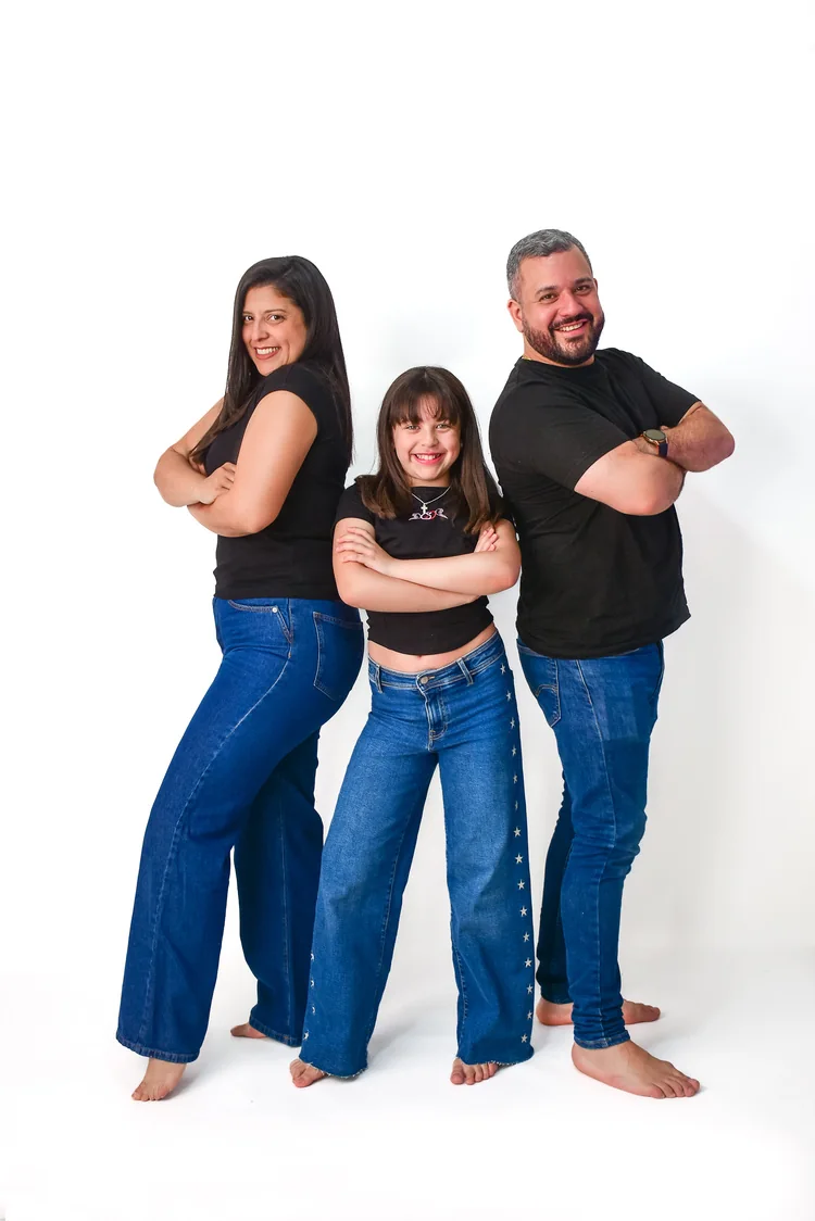 Familia de tres integrantes posando descalzos sobre fondo blanco