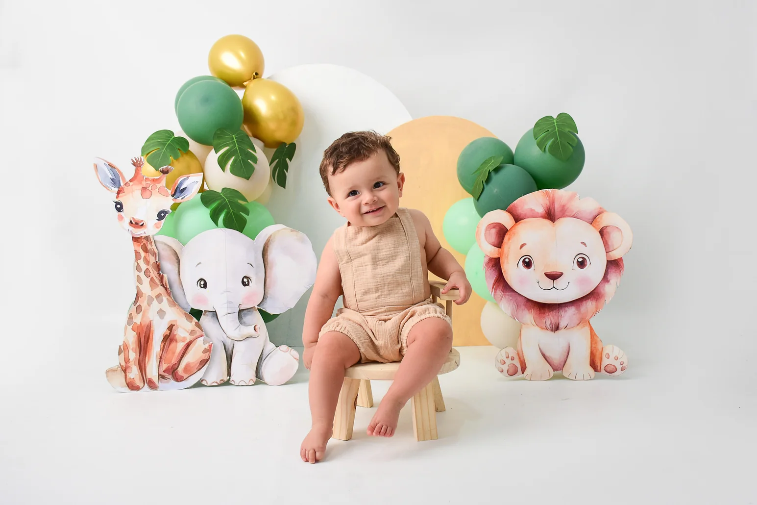 Sesión temática de safari con peluches de jirafa, elefante y león junto al bebé